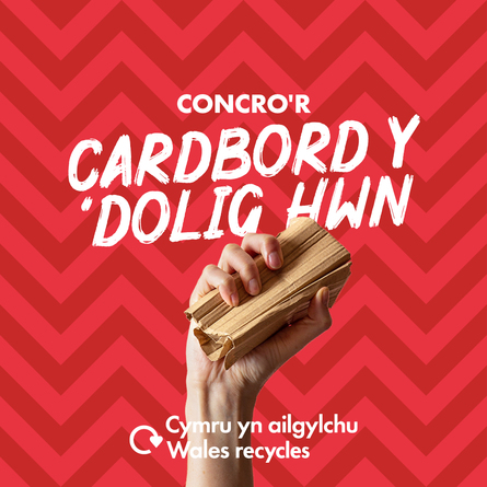 Hand holding crushed cardboard with the slogan