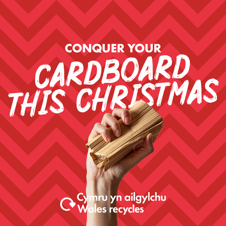 Hand holding crushed cardboard with the slogan