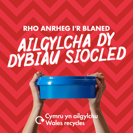 Blue plastic sweet tub held aloft by a pair of white hands with the slogan